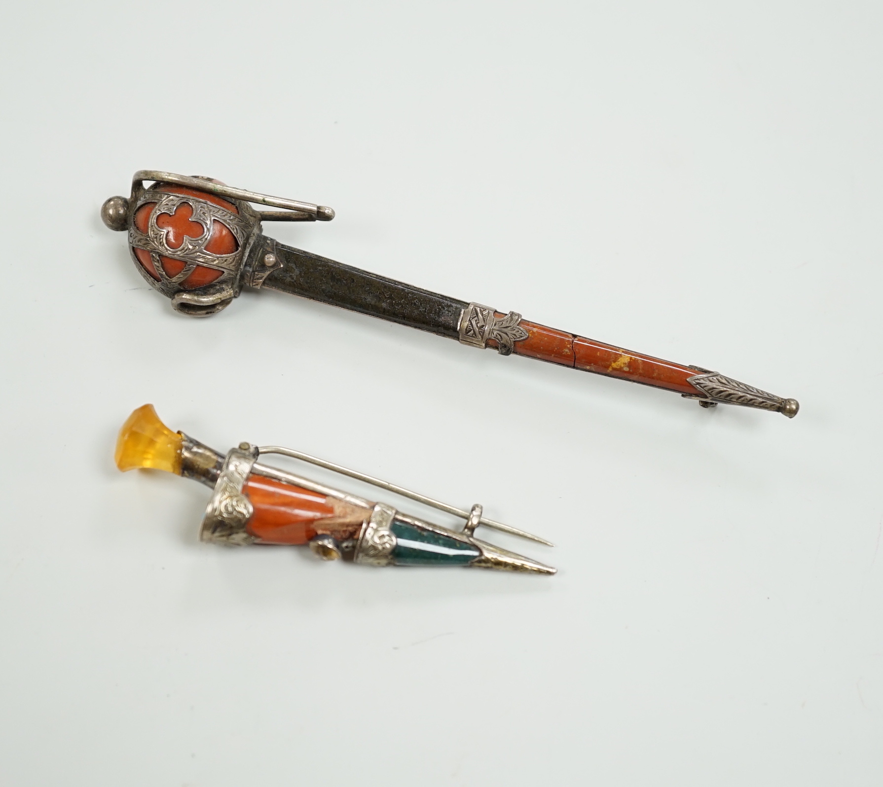 Two early 20th century white metal and Scottish hardstones set dagger or sword brooches, largest 11.6cm.